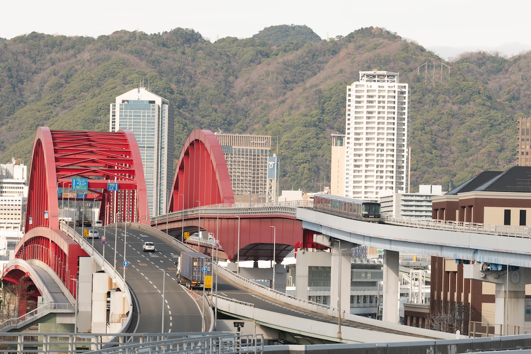 昼間の神戸大橋とポートピア大橋。道路には車が、線路にはポートライナーが走る。
