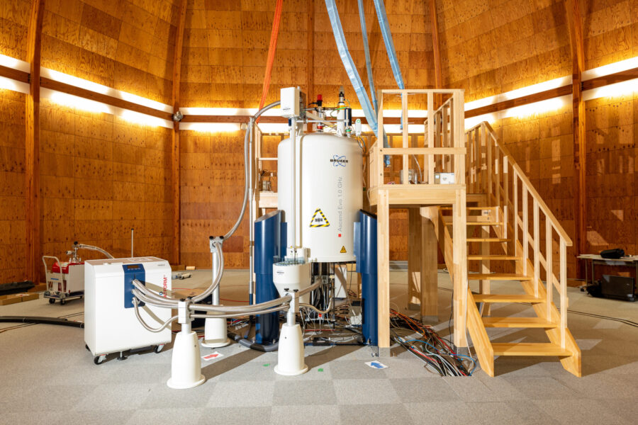 木造の実験棟の中に白い機械が設置してある。機械には木製のはしごがついている。